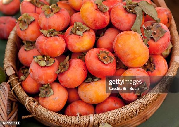 persimmons in a basket - bitter stock pictures, royalty-free photos & images