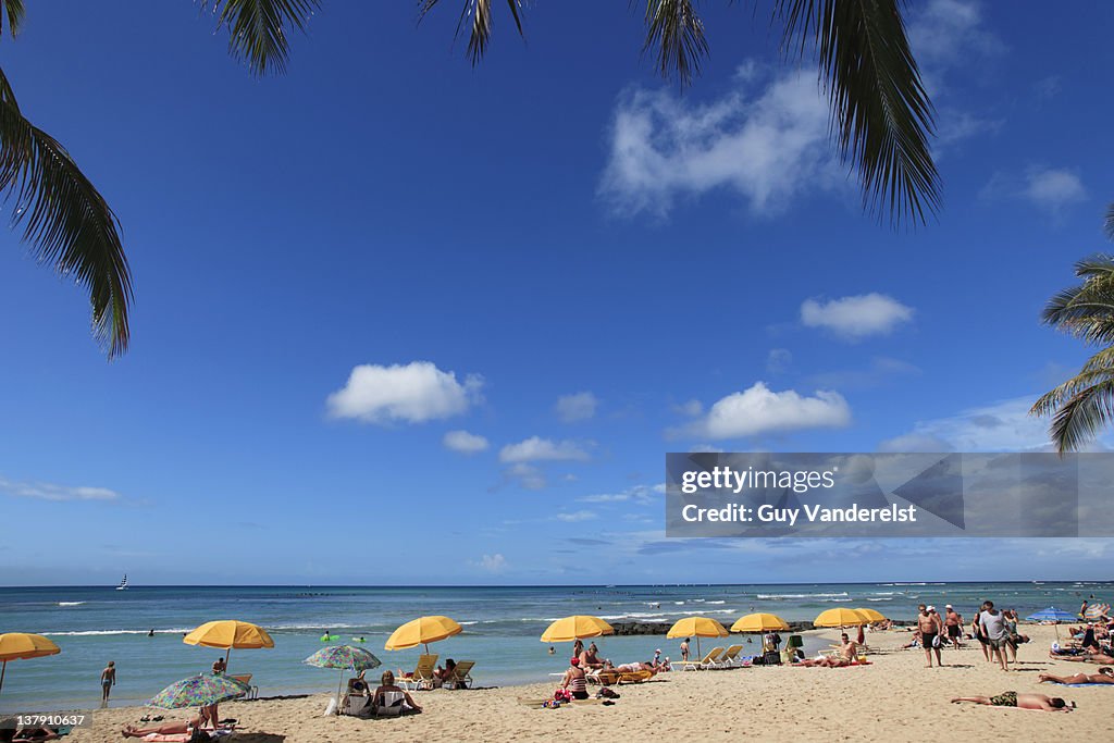 Waikiki beach with tourists on Oahu island.