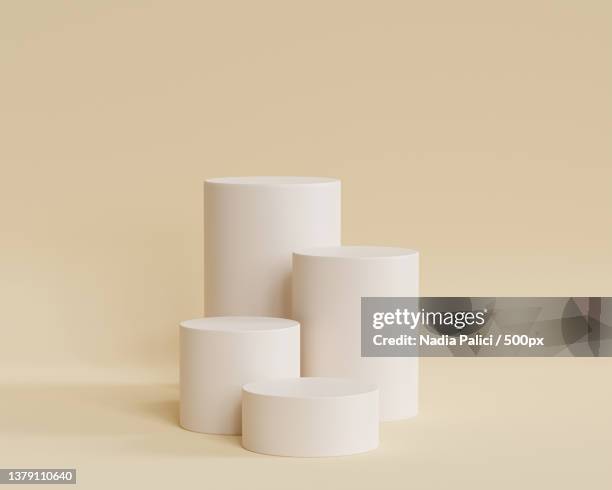 cylinder shaped podiums against beige background - plinto imagens e fotografias de stock