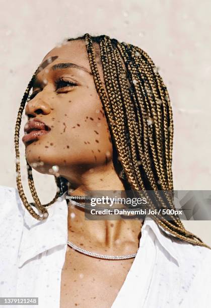 drops of ice,portrait of a young woman standing against stone wall with sun shining down,chicago,illinois,united states,usa - editorial bildbanksfoton och bilder