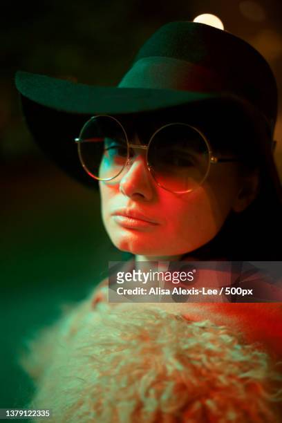 close-up of person wearing sunglasses and hat with colorful light - alexis lee stock pictures, royalty-free photos & images