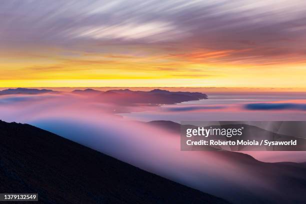 multicolored sky with fog at dawn, canary islands - atlantic islands stock-fotos und bilder