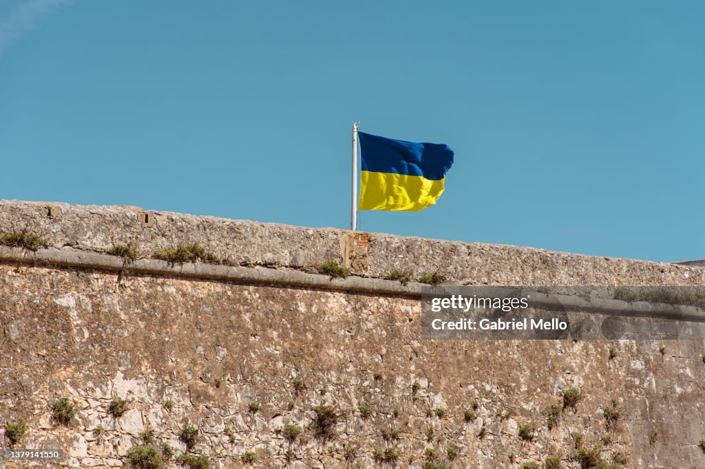 Ukrainian flag flying over the wall against blue sky