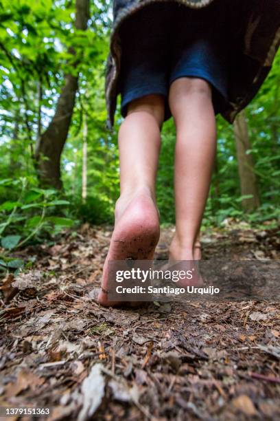 close-up of kid's feet walking barefooted on forest - boy barefoot rear view stock-fotos und bilder