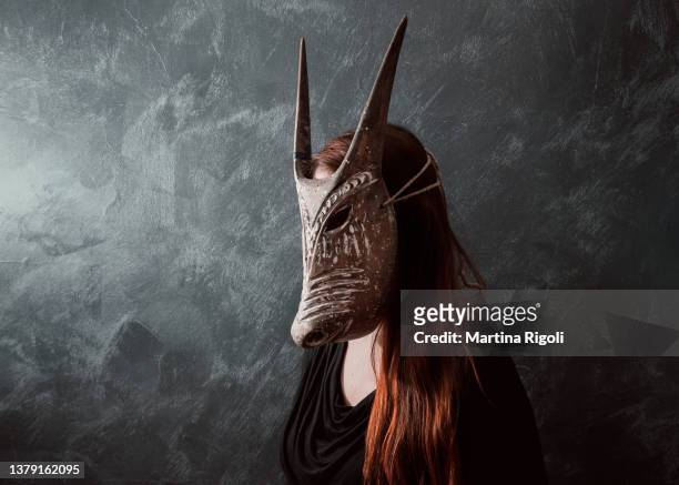 rothaariges frauenporträt mit stammeshornmaske - demon stock-fotos und bilder