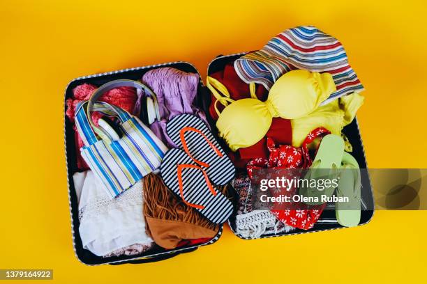 suitcase with headphones, swimwear, clothing and flip-flops. - red swimwear stock pictures, royalty-free photos & images