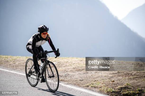 woman road cycling on italian alpine road - hairpin curve stock pictures, royalty-free photos & images