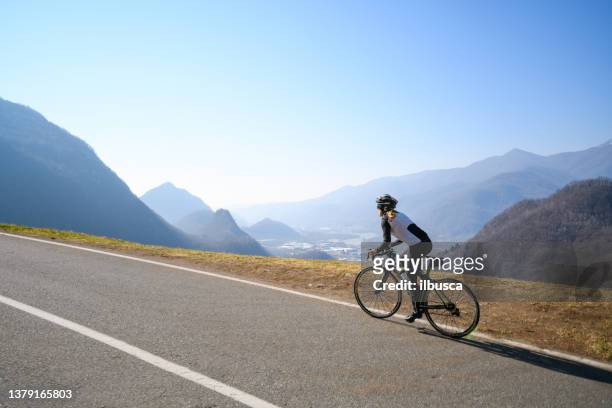 rennradfahrerinnen auf der italienischen alpenstraße - straßenradsport stock-fotos und bilder