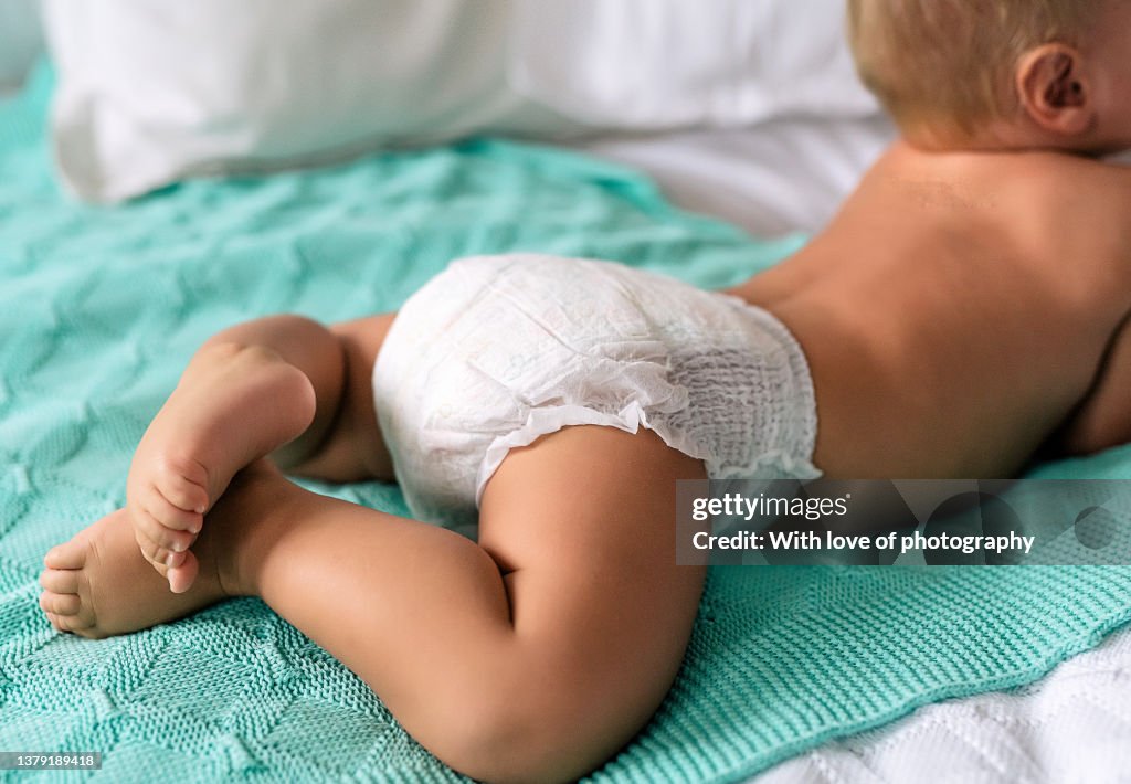 Cute baby boy 10-11 months playing in baby pants white diaper