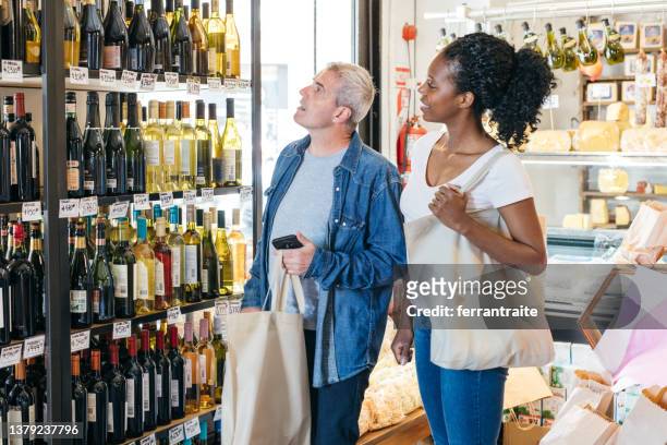 couple shopping at wine store - buying alcohol stock pictures, royalty-free photos & images