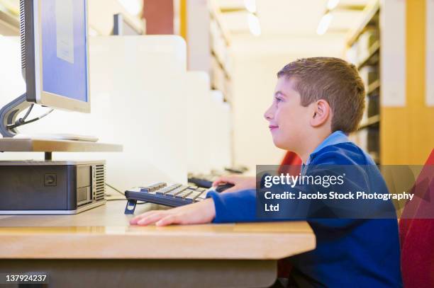 hispanic boy using computer in library - melbourne school stock pictures, royalty-free photos & images