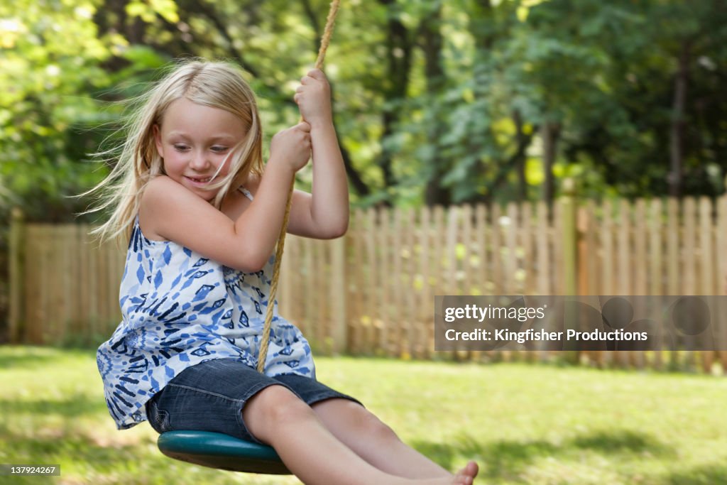 Caucasian girl swinging on swing