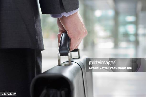 mixed race businessman carrying briefcase - attaché stockfoto's en -beelden