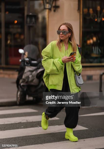 Sonia Lyson is wearing Attico silver shades, Lumina green bomber jacket, The Frankie Shop black leather pants, Prada silver hobo bag and Ugg green...