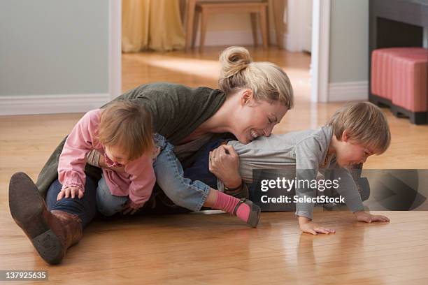 mother and children wrestling - rough housing stockfoto's en -beelden