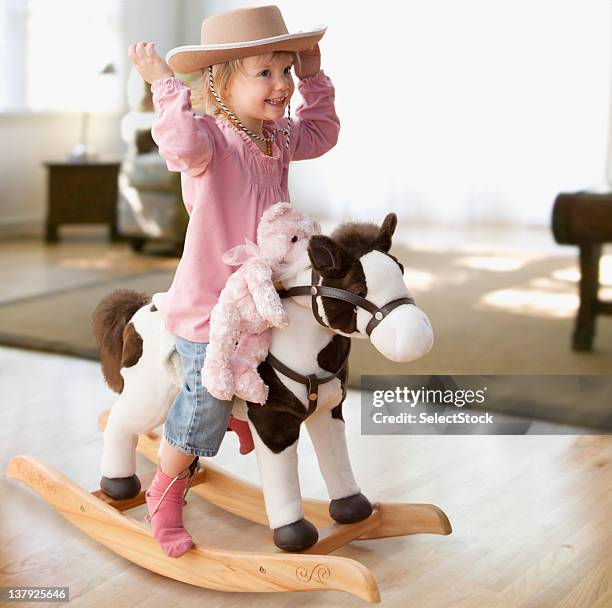 girl on rocking horse - girl and blond hair and cowboy hat stock pictures, royalty-free photos & images