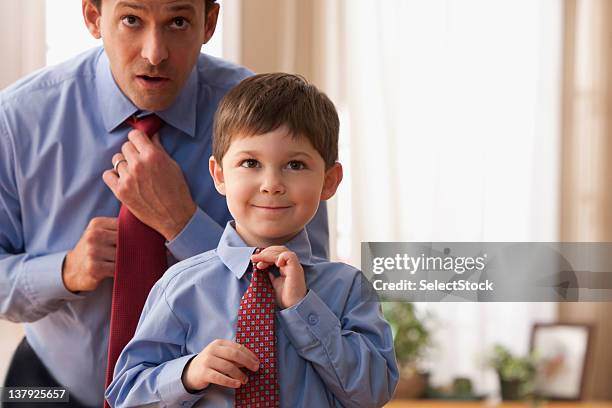 father and son fixing ties together - getting dressed stockfoto's en -beelden