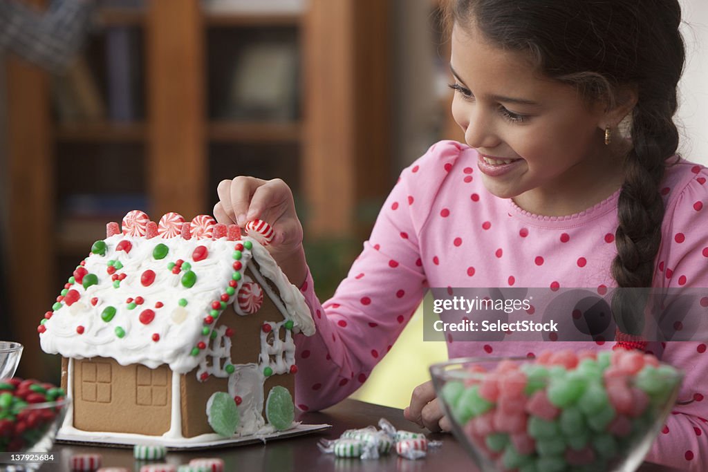 Girl decorating gingerbread house