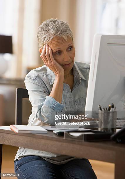 mujer mirando cansada frente a su ordenador - american red cross fotografías e imágenes de stock
