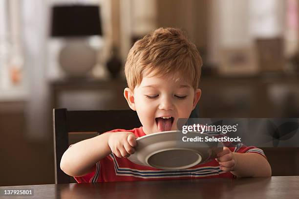 young boy licking plate - childhood hunger stock pictures, royalty-free photos & images