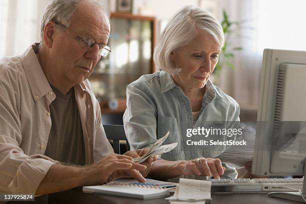 older couple paying bills on computer - pension money stock pictures, royalty-free photos & images