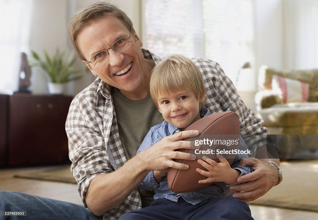 Father and son holding football