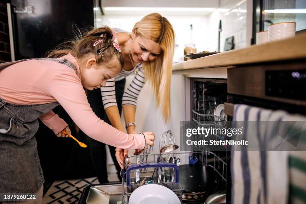 she is the cutest assistant - loading dishwasher stock pictures, royalty-free photos & images