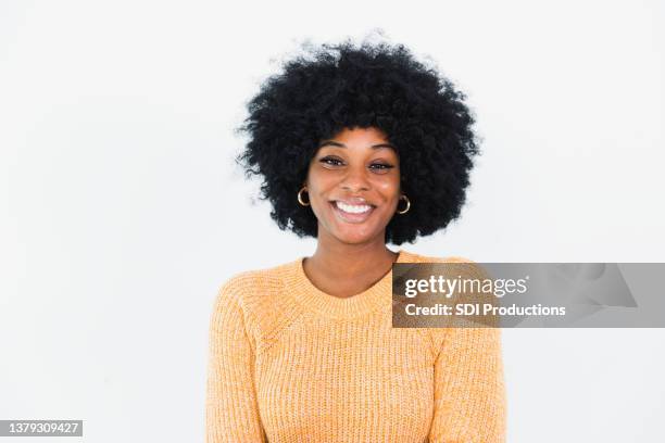 waist up portrait smiling young woman in yellow sweater - smiling woman waist up stock pictures, royalty-free photos & images