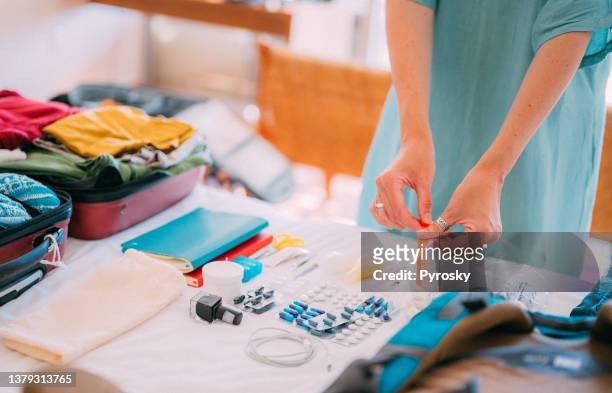 a woman's hand packs cosmetics and medicines for the trip in a bag with a zipper. - closing book stock pictures, royalty-free photos & images