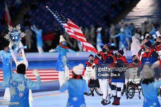 Flag bearers Tyler Carter and Danelle Umstead of Team United States lead their team out during the Opening Ceremony of the Beijing 2022 Winter...