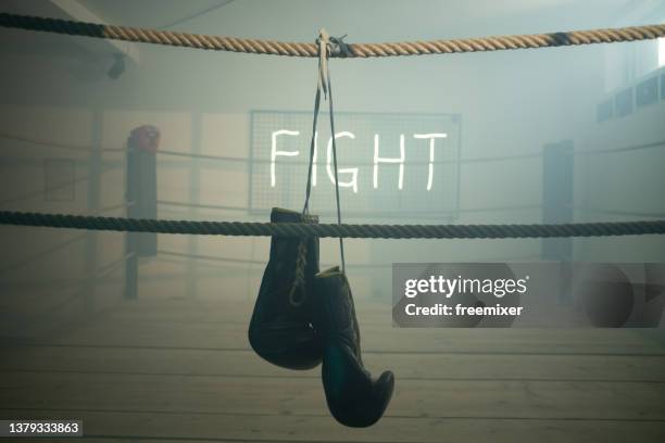 guantoni da boxe appesi a una corda - empty boxing ring foto e immagini stock