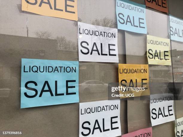 Liquidation Sale signs in business storefront, Queens, New York.