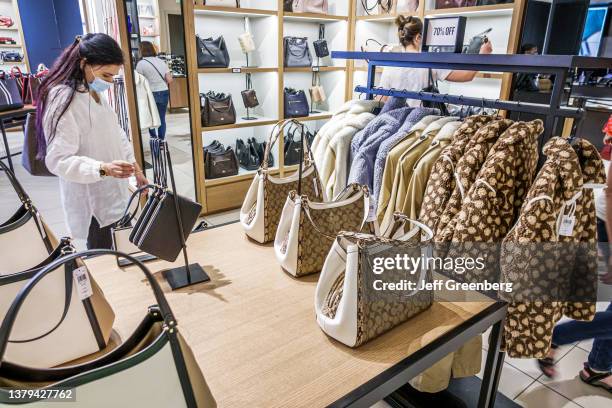 Florida, Orlando Vineland Premium Outlets, Coach leather goods woman shopping for purse.