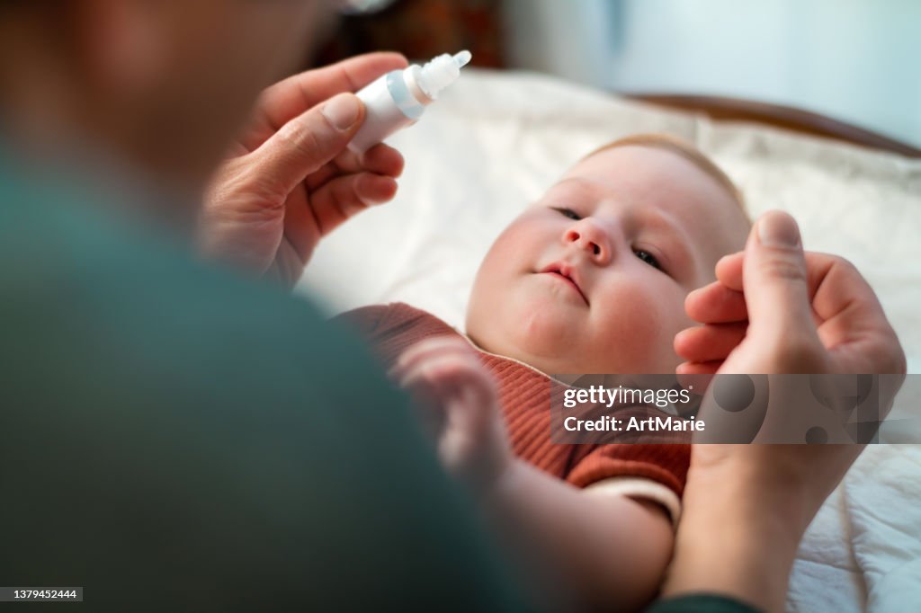 Father giving his baby girl nasal drops
