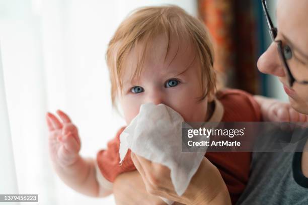 mother cleaning nose of her baby girl - mucus stock pictures, royalty-free photos & images