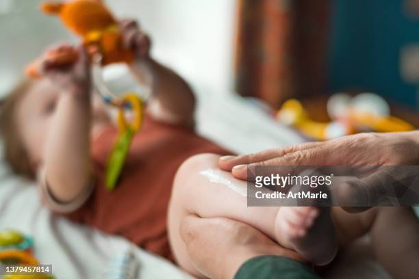 father applying moisturizing and protective cream to his baby girl - beautiful male feet stock pictures, royalty-free photos & images