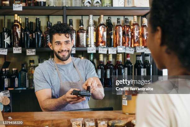 kontaktloses bezahlen im convenience store - convenience store counter stock-fotos und bilder