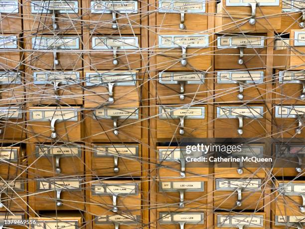 traditional wooden library card catalog cabinet covered in string - chaos to order ストックフォトと画像