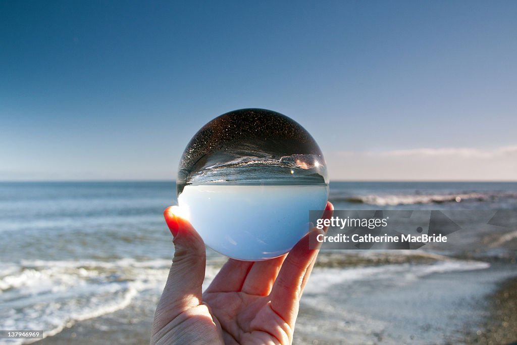 Glass crystal ball held up by hand