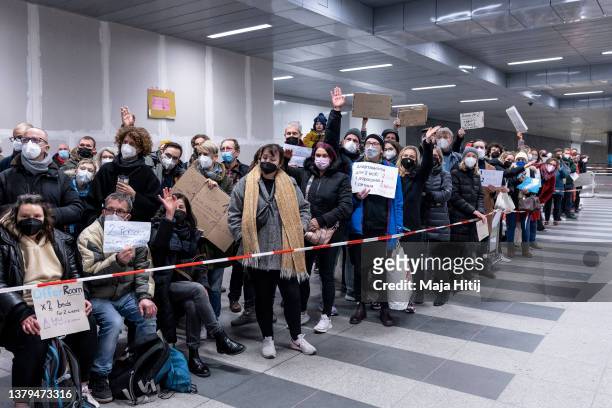 People line up to offer a place to stay for refugees fleeing Ukraine arriving by train from Poland at Hauptbahnhof main railway station on March 4,...