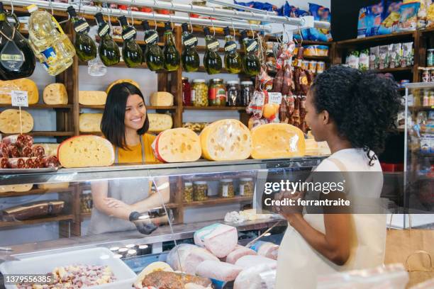 grocery store owner serving customer orders - deli counter stockfoto's en -beelden