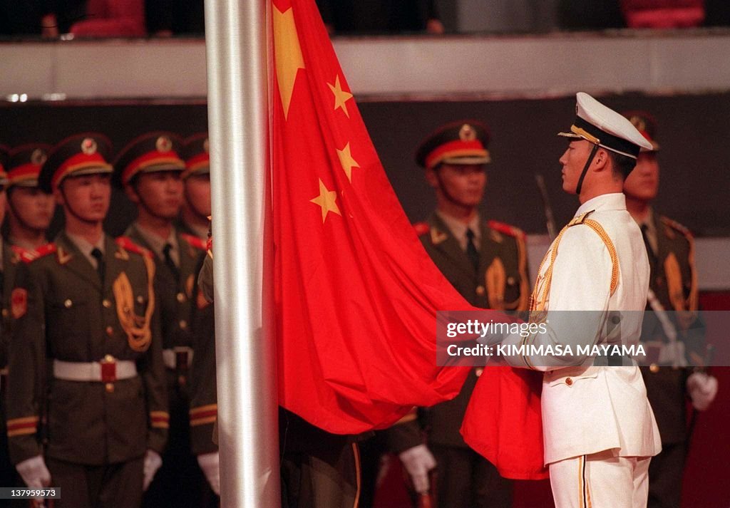 A PLA soldier raises the Chinese flag du