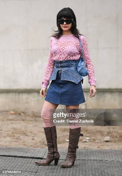 Maria Bernad is seen wearing a pink Loewe sweater, Loewe jean skirt with waistband and brown boots outside the Loewe show during Paris Fashion Week...
