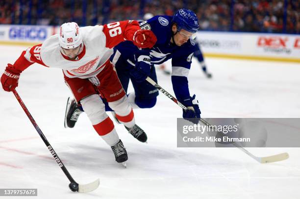 Joe Veleno of the Detroit Red Wings and Mikhail Sergachev of the Tampa Bay Lightning fight for the puck during a game at Amalie Arena on March 04,...