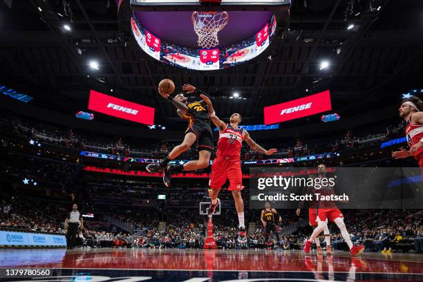 John Collins of the Atlanta Hawks goes to the basket against Kyle Kuzma of the Washington Wizards during the second half at Capital One Arena on...