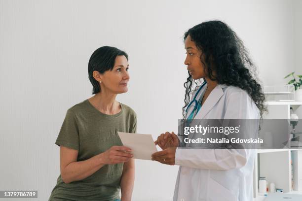 african-american female doctor explaining list of medicines to mature patient at appointment - asthma in adults imagens e fotografias de stock