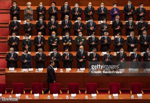 Chinese President Xi Jinping, bottom left, is applauded by members of the government as he arrives at the opening session of the National Peoples...