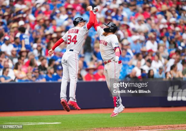 Justin Turner of the Boston Red Sox celebrates his home run with third base coach Kyle Hudson against the Toronto Blue Jays during the ninth inning...