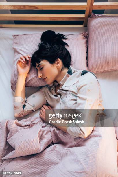 sound asleep: overhead waist up shot of a pretty woman in pyjamas sleeping on a bed - beautiful woman sleeping stock pictures, royalty-free photos & images