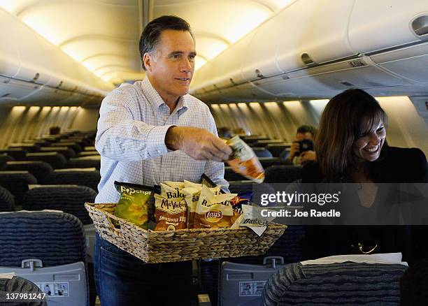 Republican presidential candidate and former Massachusetts Gov. Mitt Romney tosses snacks to reporters on his plane at the Jacksonville International...